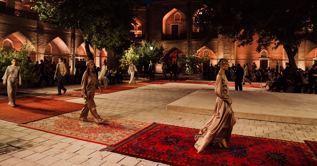 Modelos desfilando sobre alfombras uzbekas en el patio de la madraza Abulkasim, Tashkent